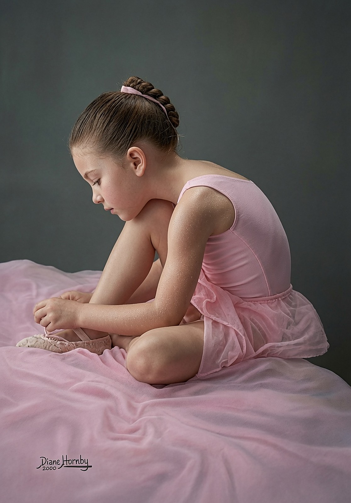 Portrait of a young ballerina in pink, seated